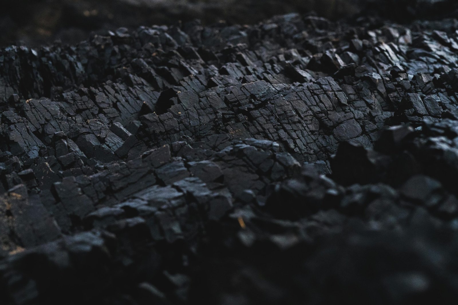 A detailed close-up of dark charcoal texture, showcasing its rough and jagged surface.